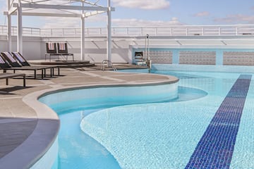 a pool with chairs and a roof over it