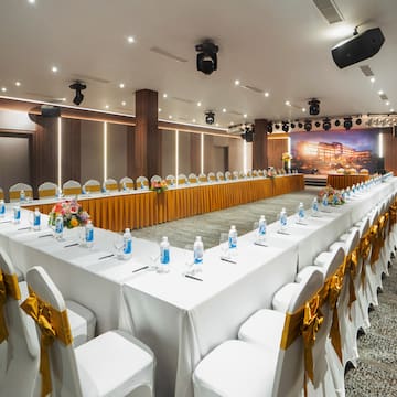 a long white table with white chairs and yellow bows