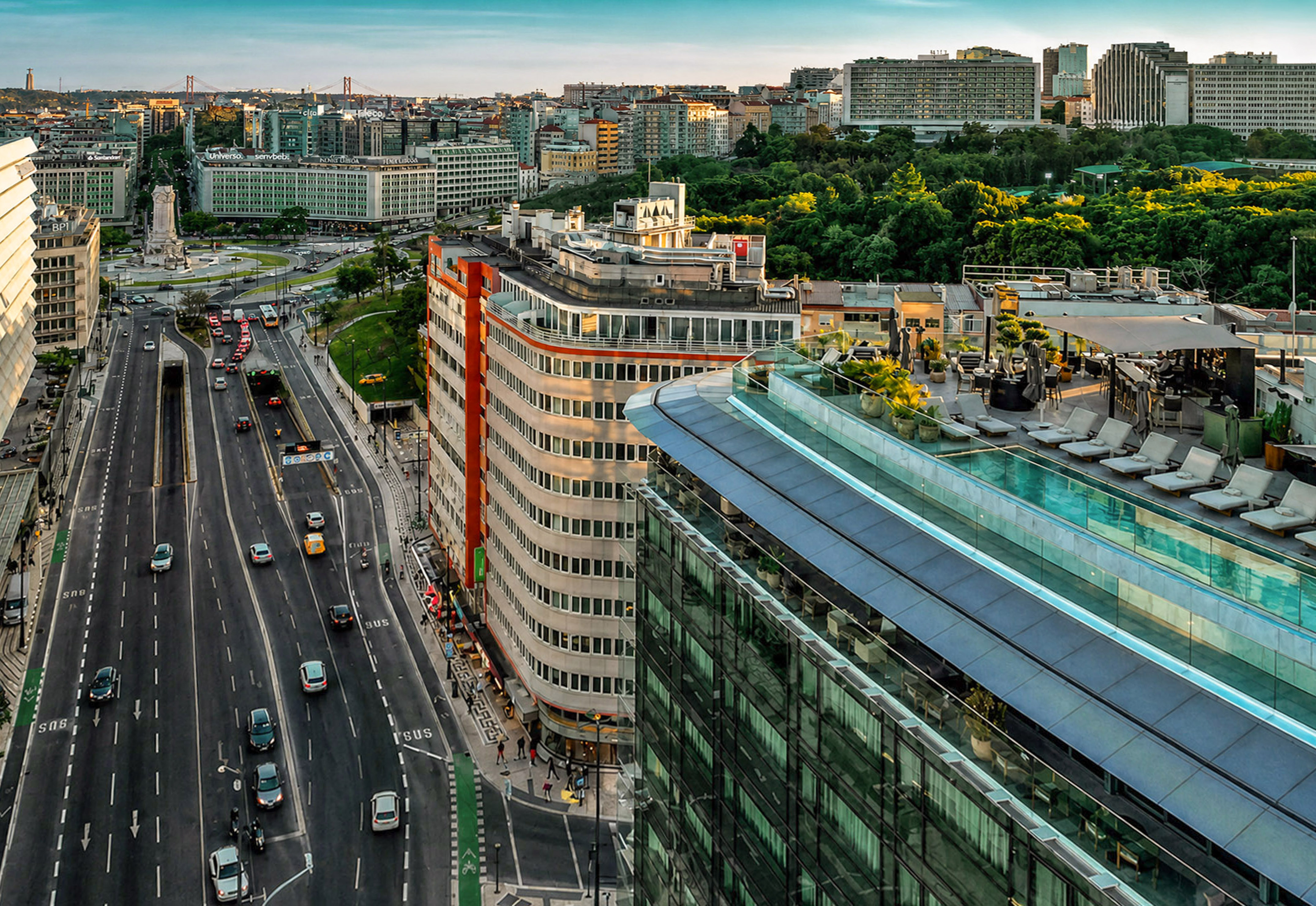 Aerial view of Lisbon city with busy highway, modern buildings, and rooftop pool.