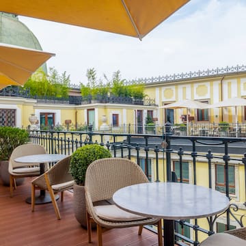 a patio with tables and chairs and umbrellas