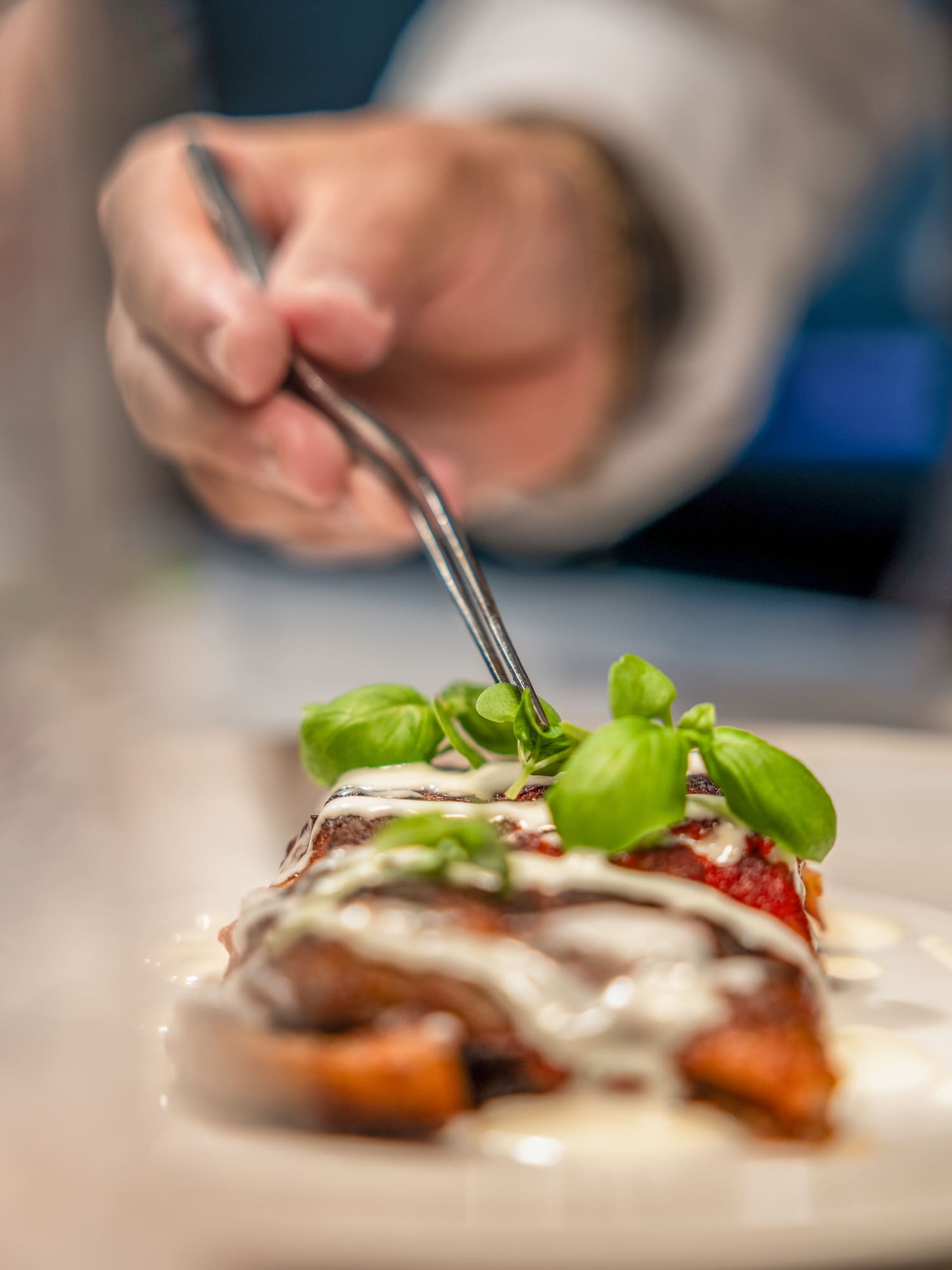 a person holding a fork over food