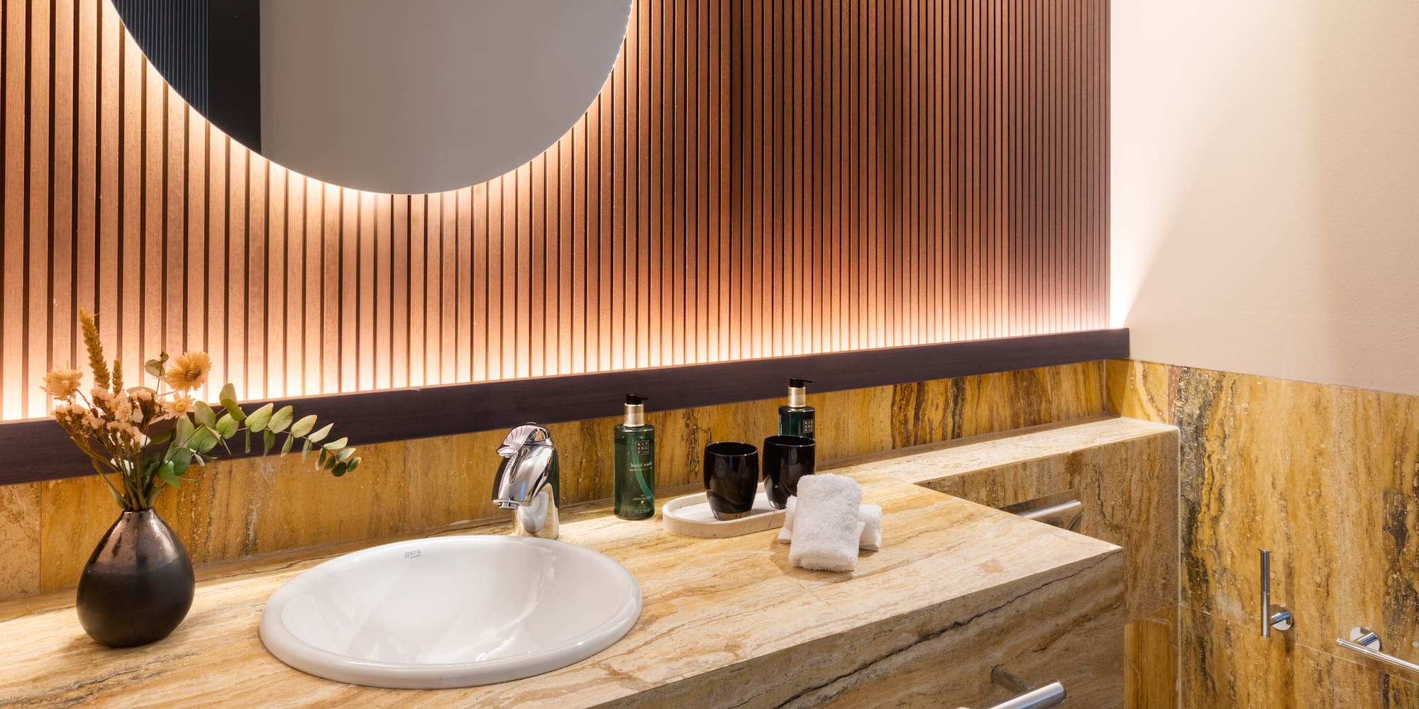 a bathroom with a round mirror and a marble counter top