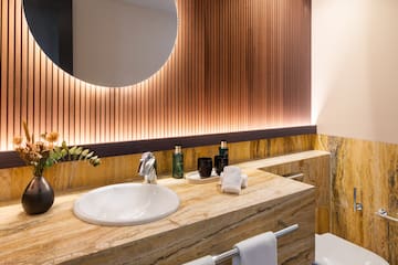 a bathroom with a round mirror and a marble counter top
