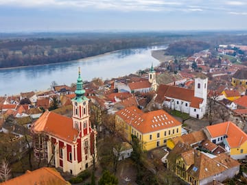 a city with red roofs and a river