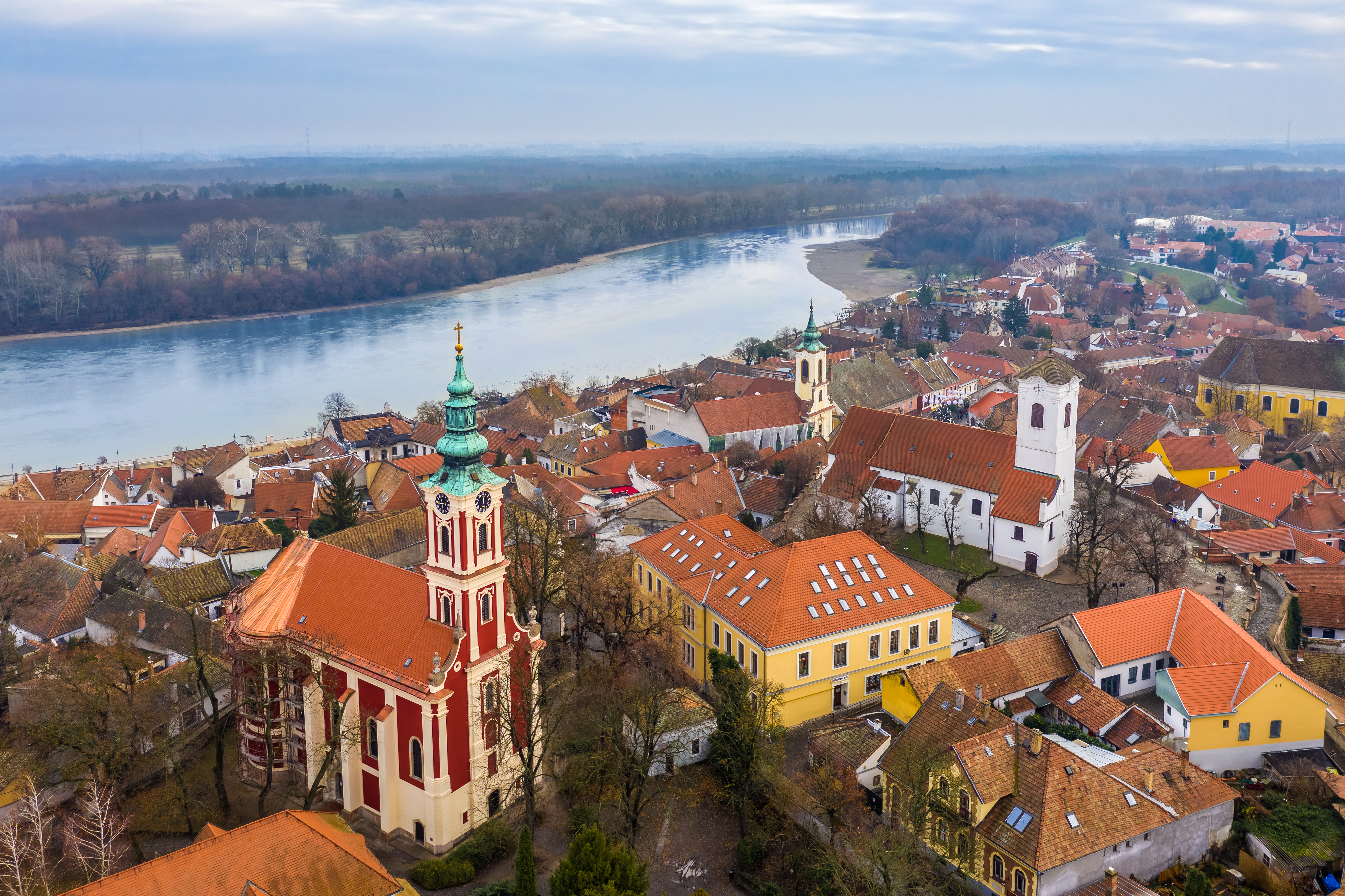 a city with red roofs and a river