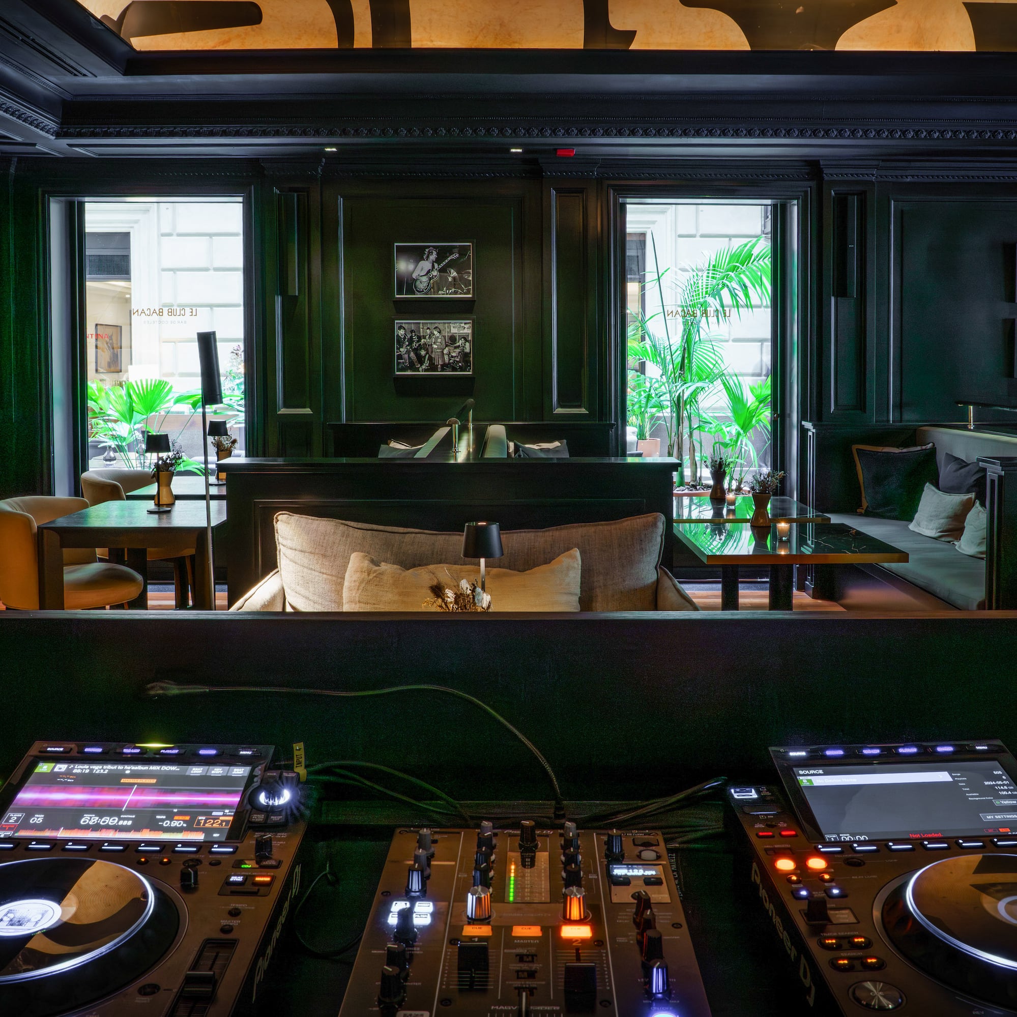 Illuminated DJ setup in a sophisticated dark bar lounge interior.