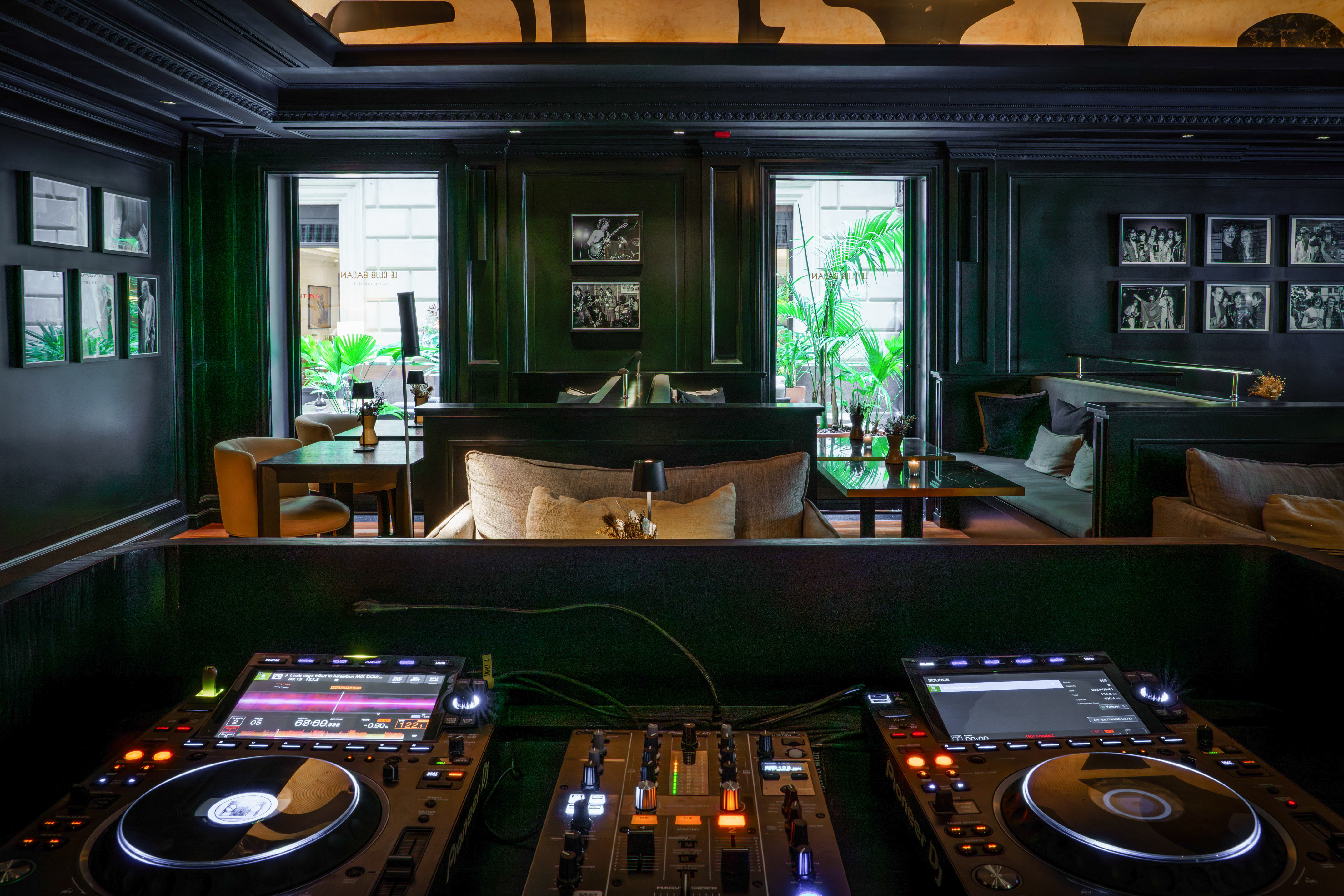 Illuminated DJ setup in a sophisticated dark bar lounge interior.
