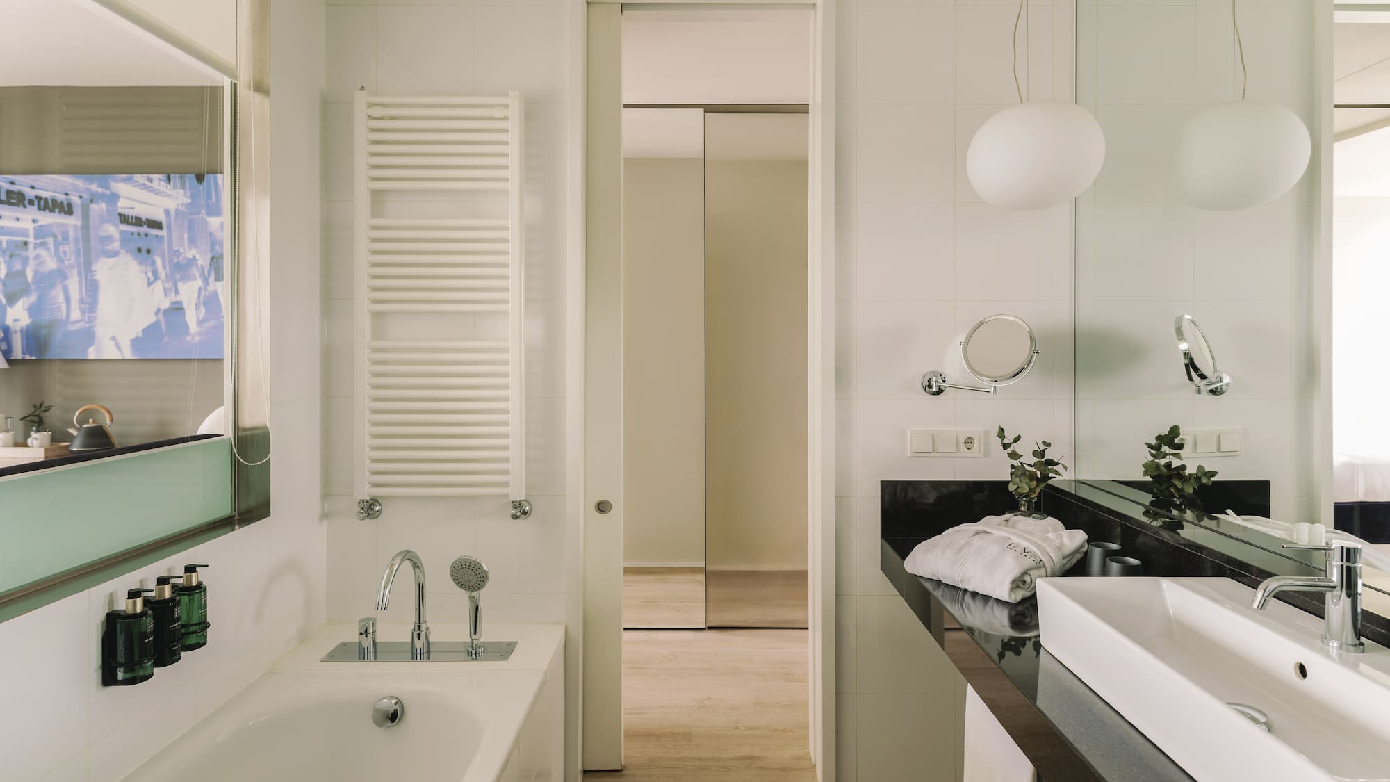 Baño moderno de hotel con bañera, lavabo y toallero.