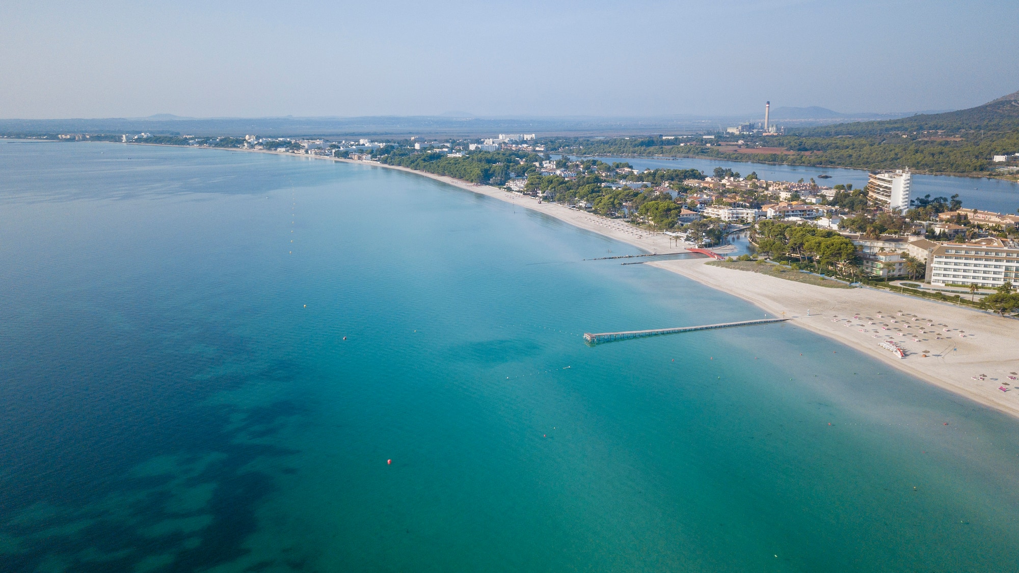 a beach with a body of water and a city