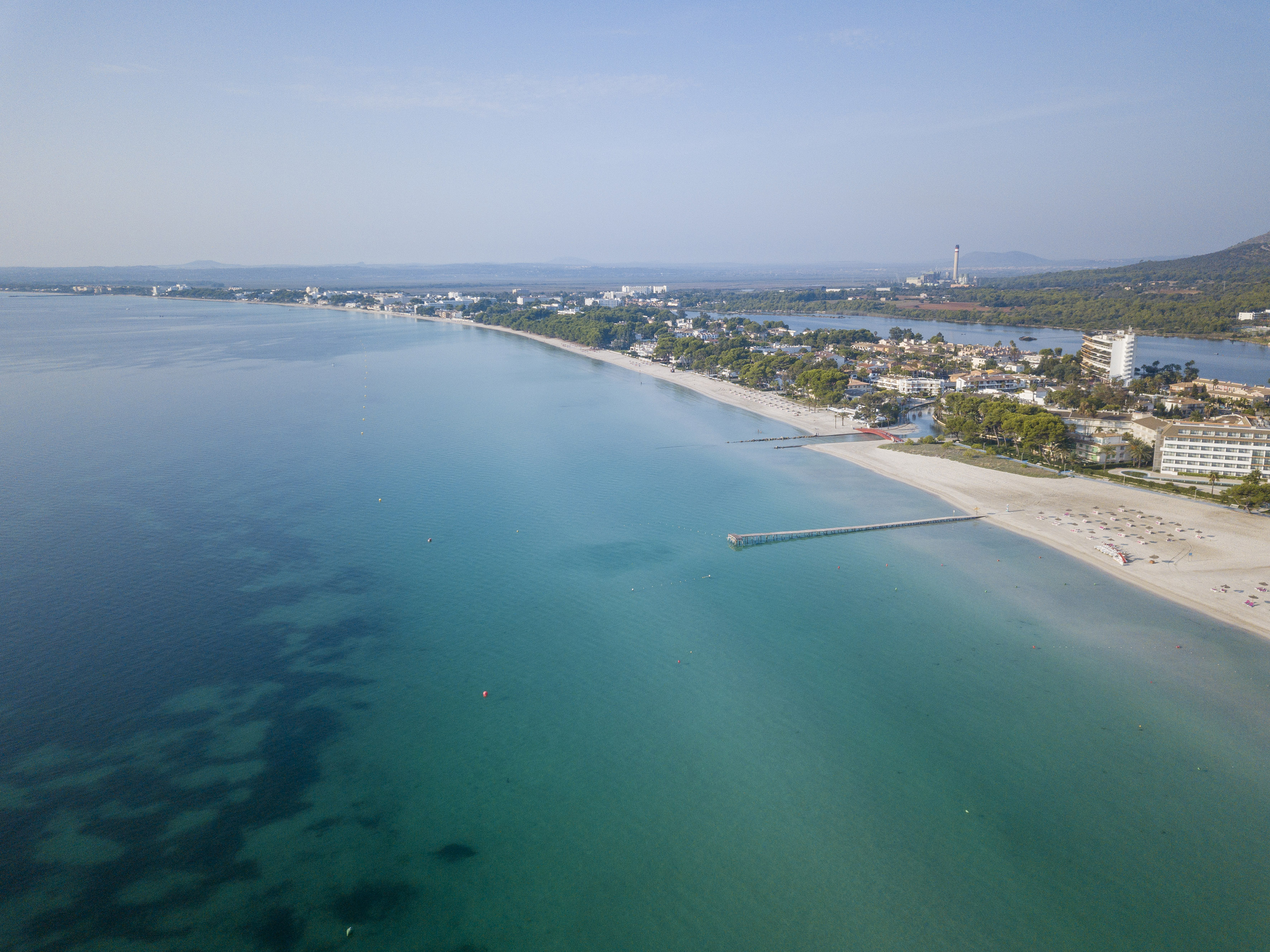 a beach with a body of water and a city