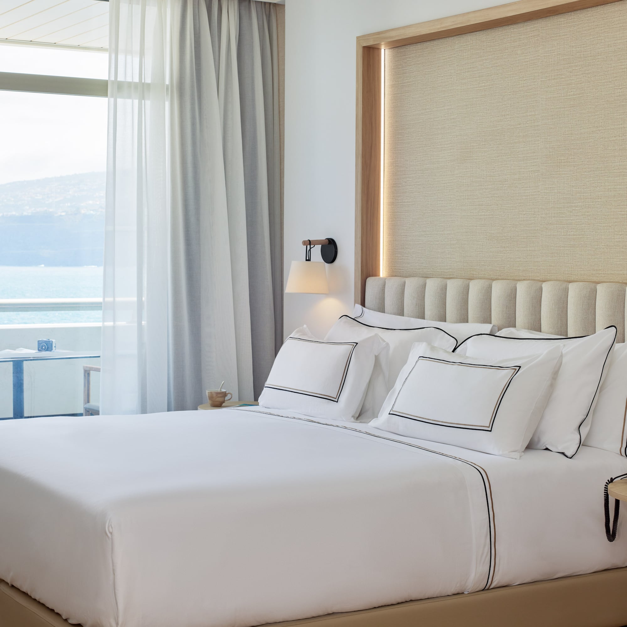 a bed with white sheets and pillows