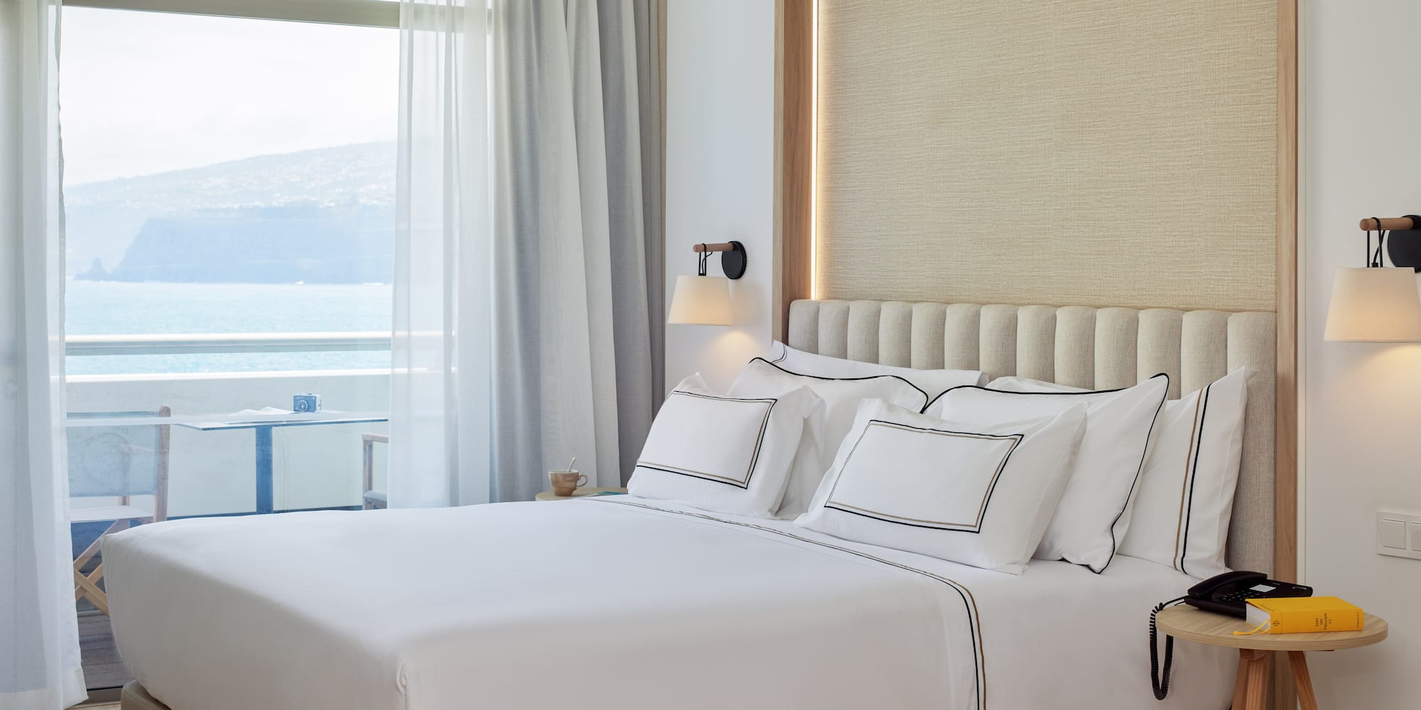 a bed with white sheets and pillows