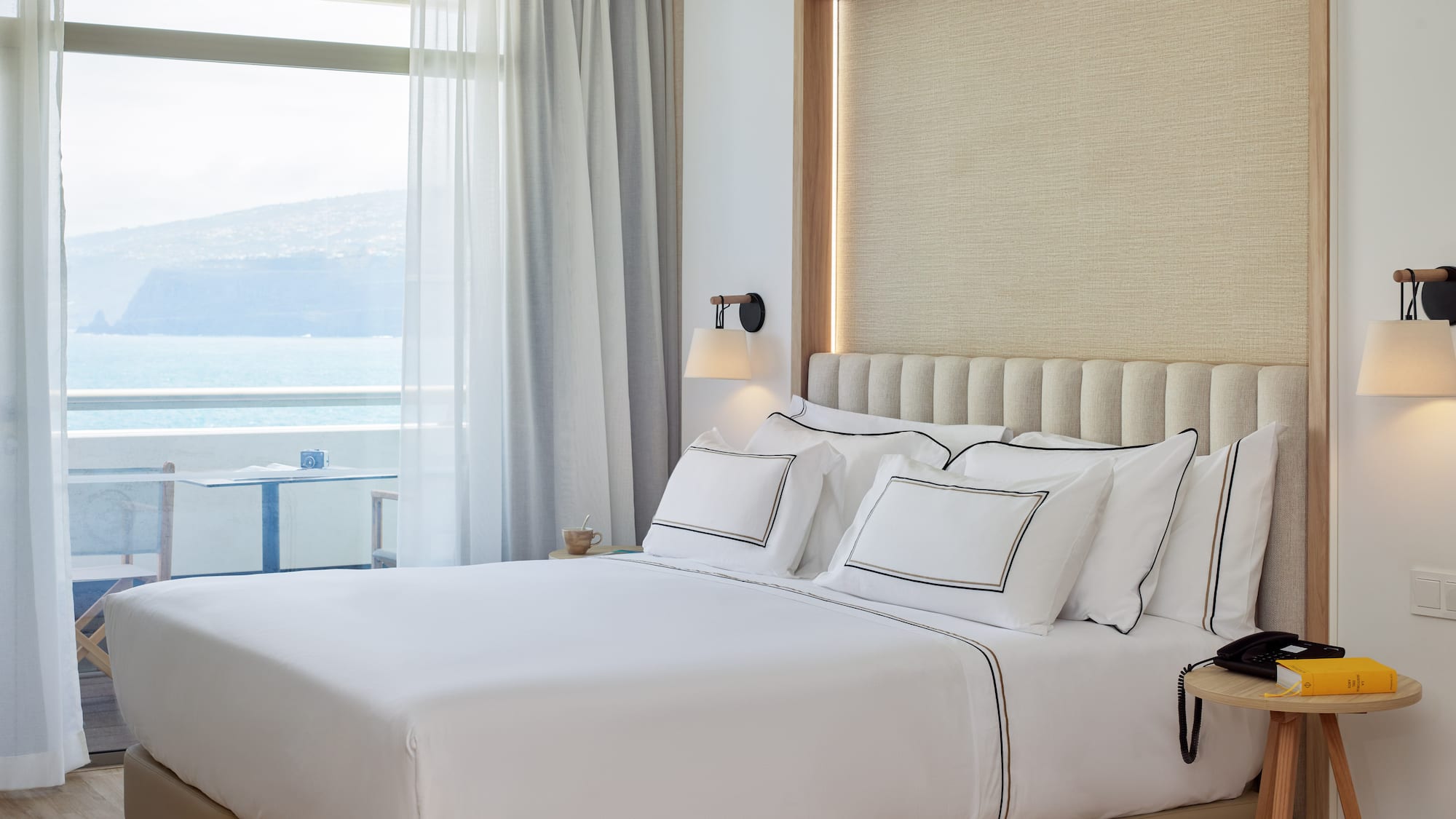 a bed with white sheets and pillows