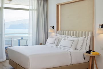 a bed with white sheets and pillows