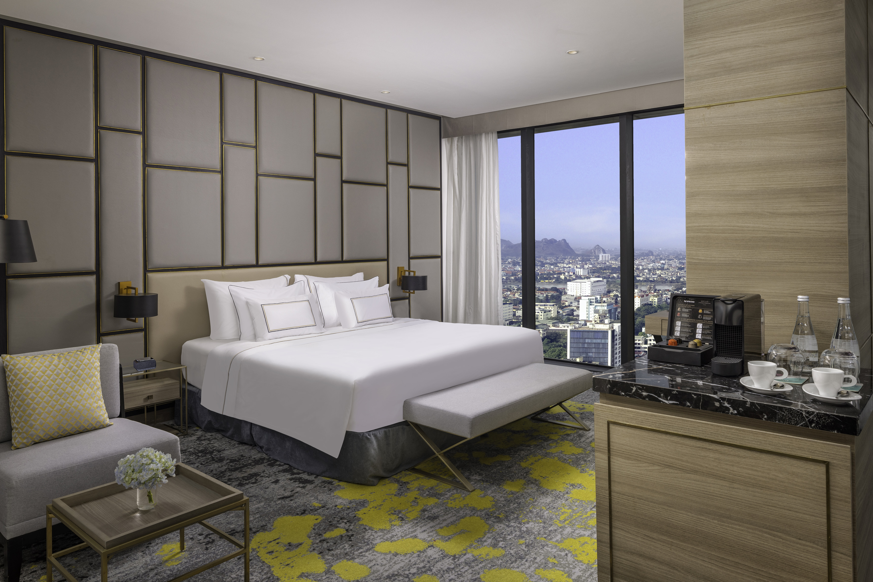 Luxury hotel room with king bed, city view, and modern design.