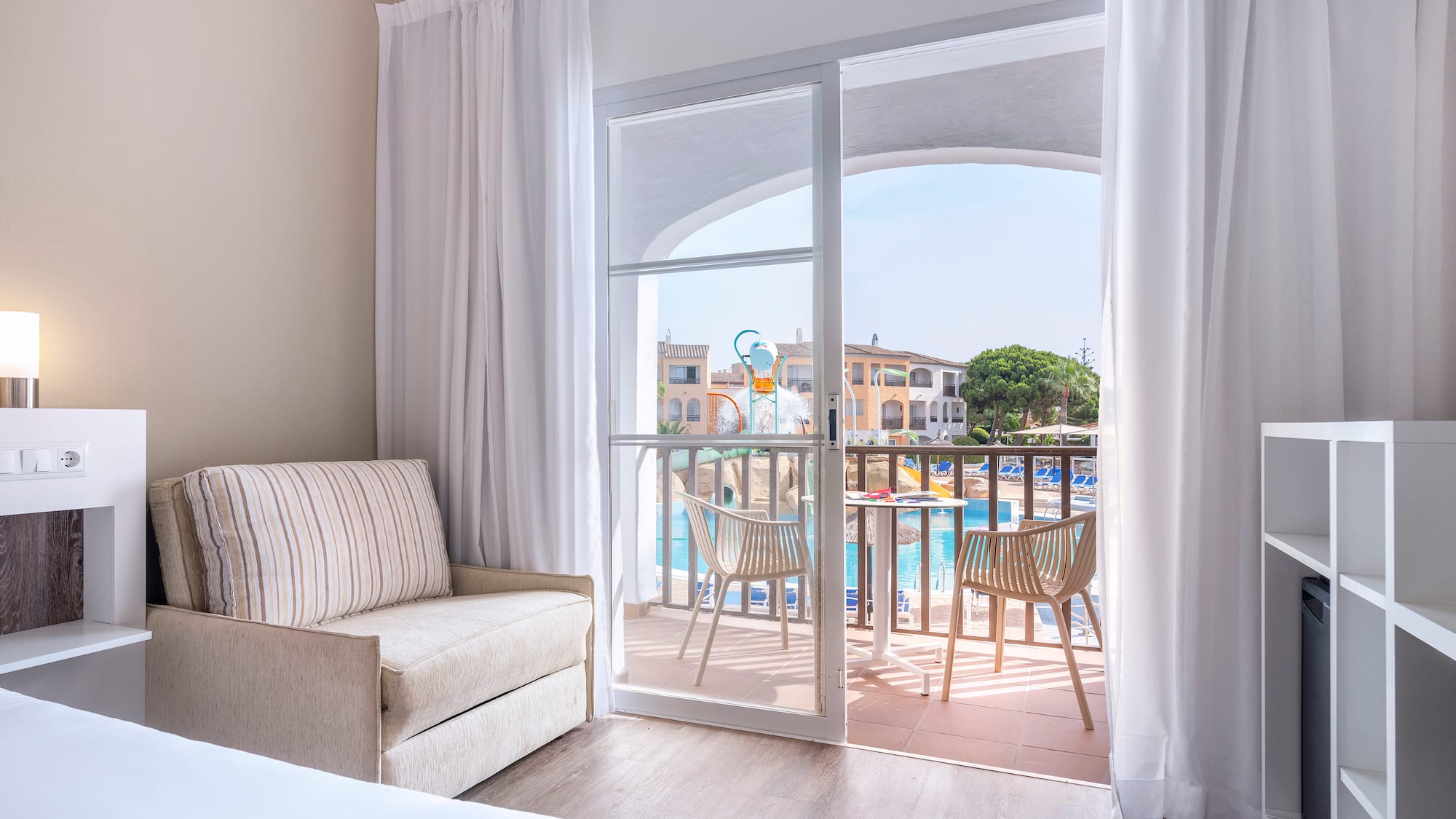 a room with a bed and a chair and a pool