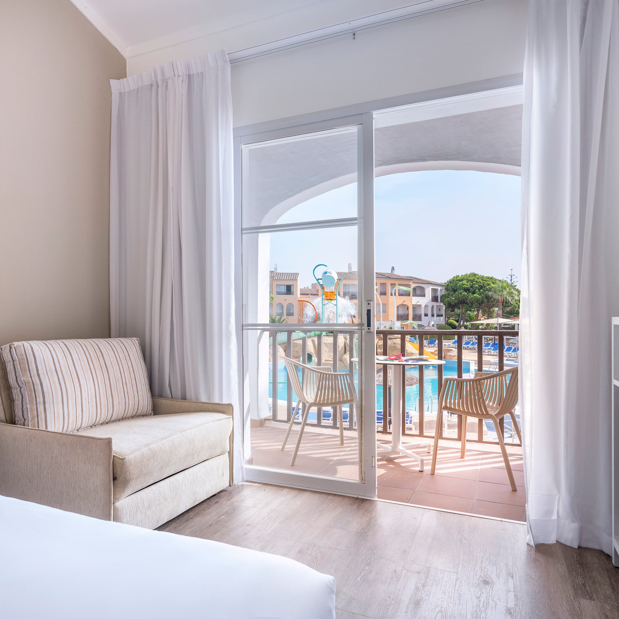 a room with a bed and a chair and a pool