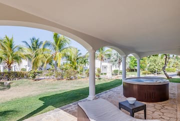 a hot tub with a table and chairs on a patio with palm trees