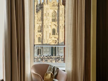 a chair in front of a window with a large building in the background