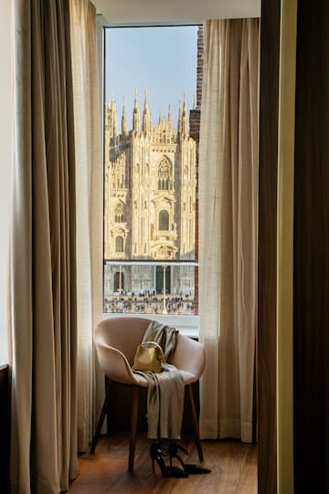 a chair in front of a window with a large building in the background