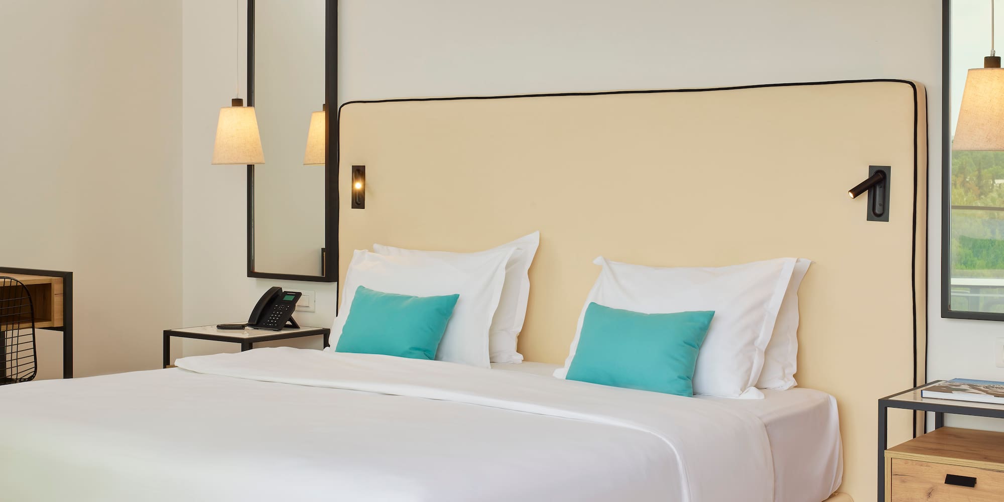 a bed with white sheets and blue pillows