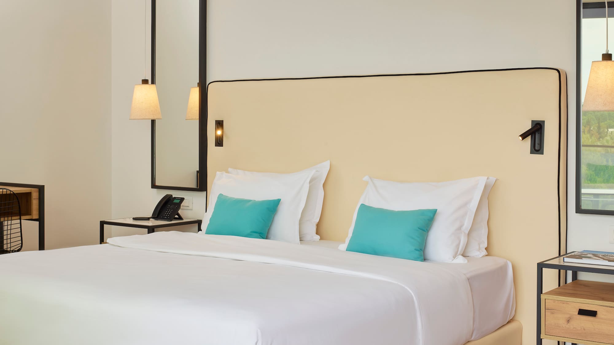 a bed with white sheets and blue pillows