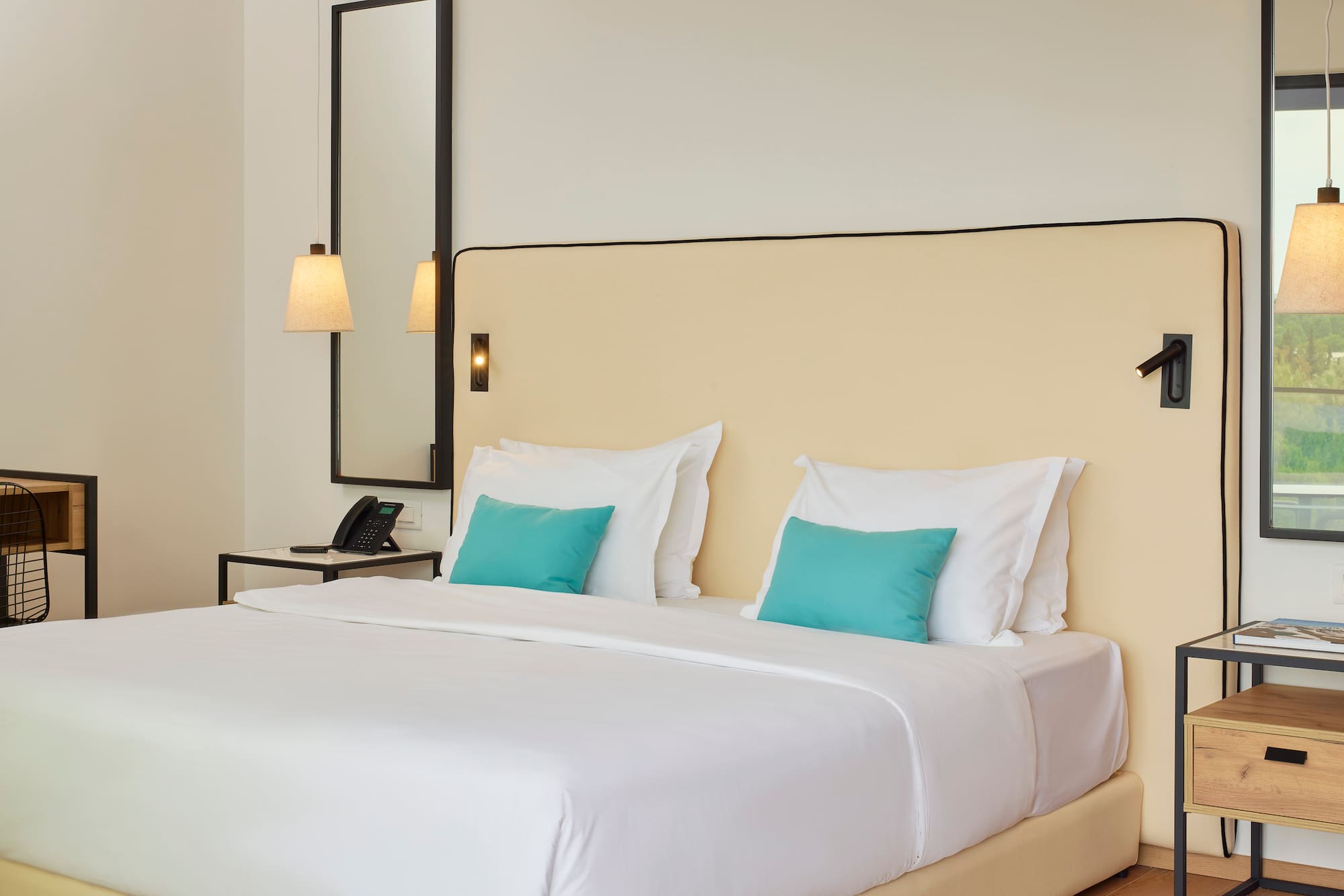 a bed with white sheets and blue pillows