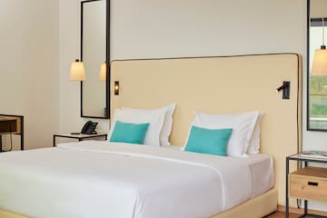 a bed with white sheets and blue pillows