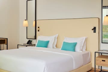 a bed with white sheets and blue pillows