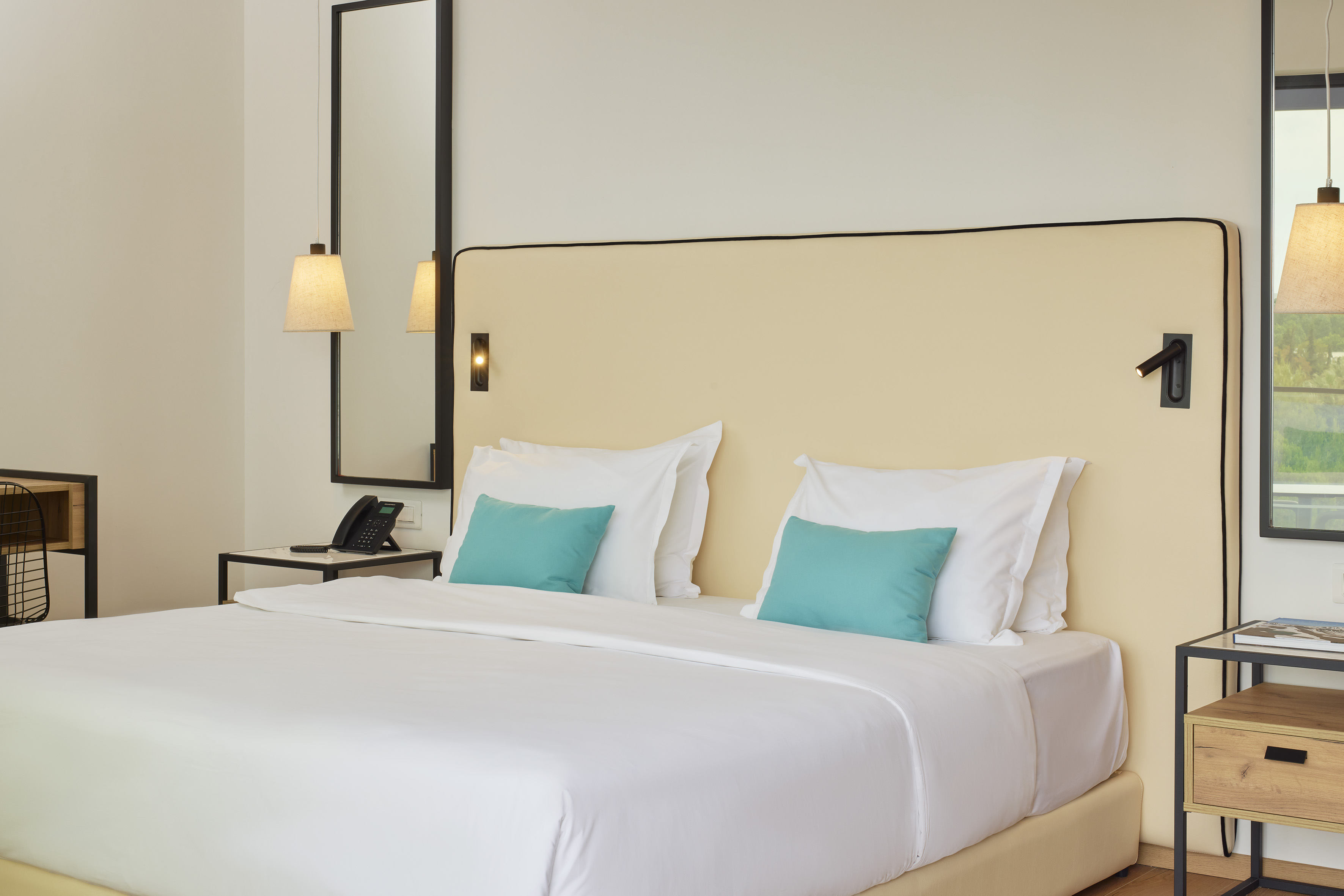 a bed with white sheets and blue pillows