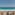 Hotel balcony with chairs, table, and stunning turquoise ocean view.
