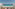Hotel balcony with chairs, table, and stunning turquoise ocean view.