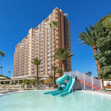 a pool with a slide in front of a building