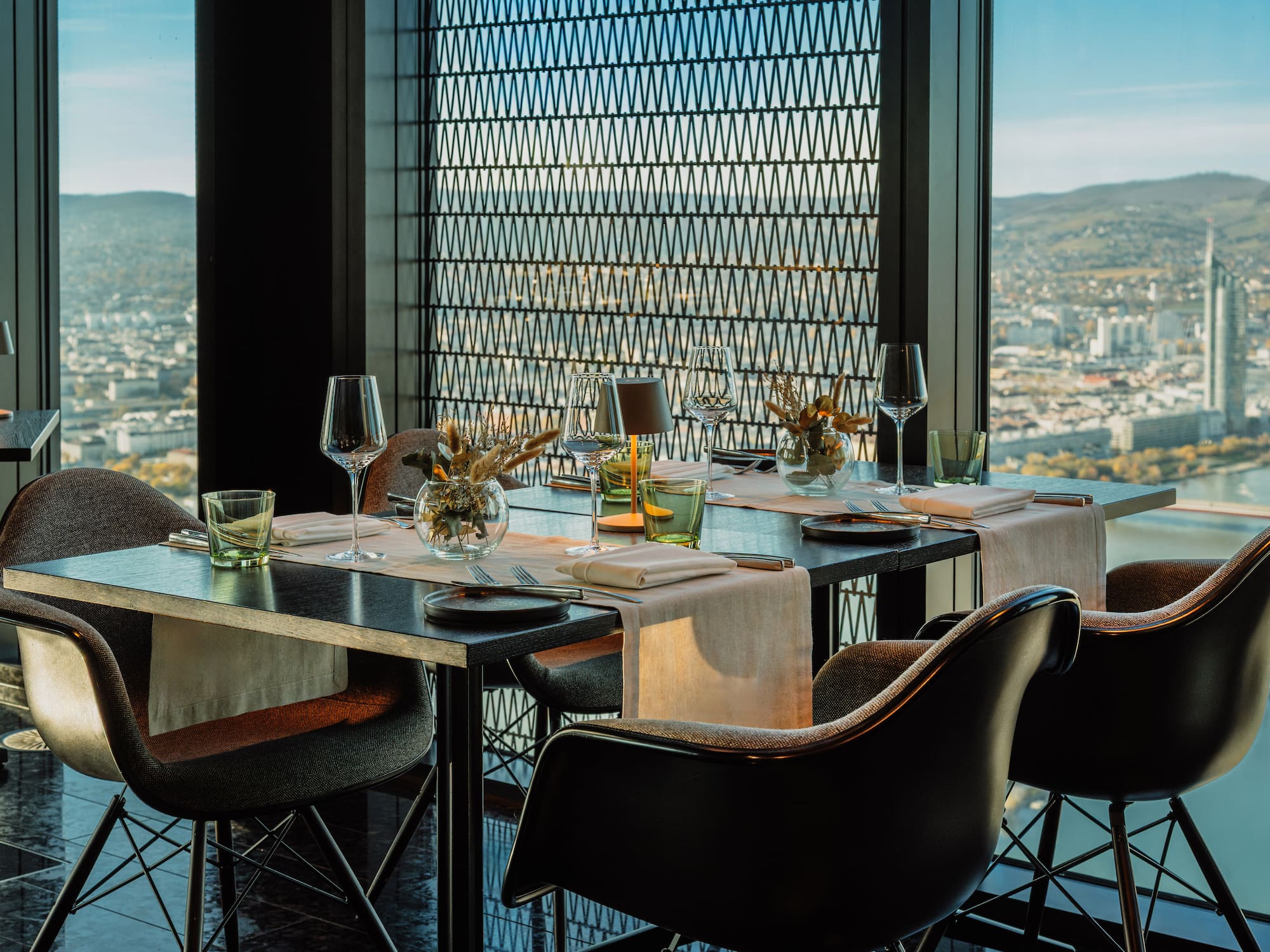 a table set for a dinner with chairs and glasses