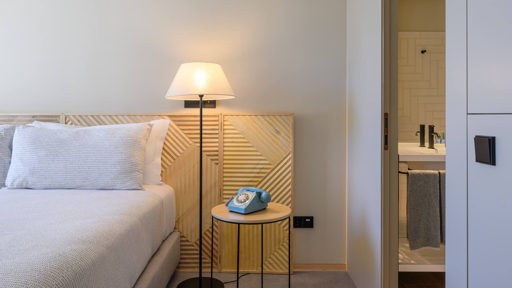 a bed with a telephone on the side of the bed
