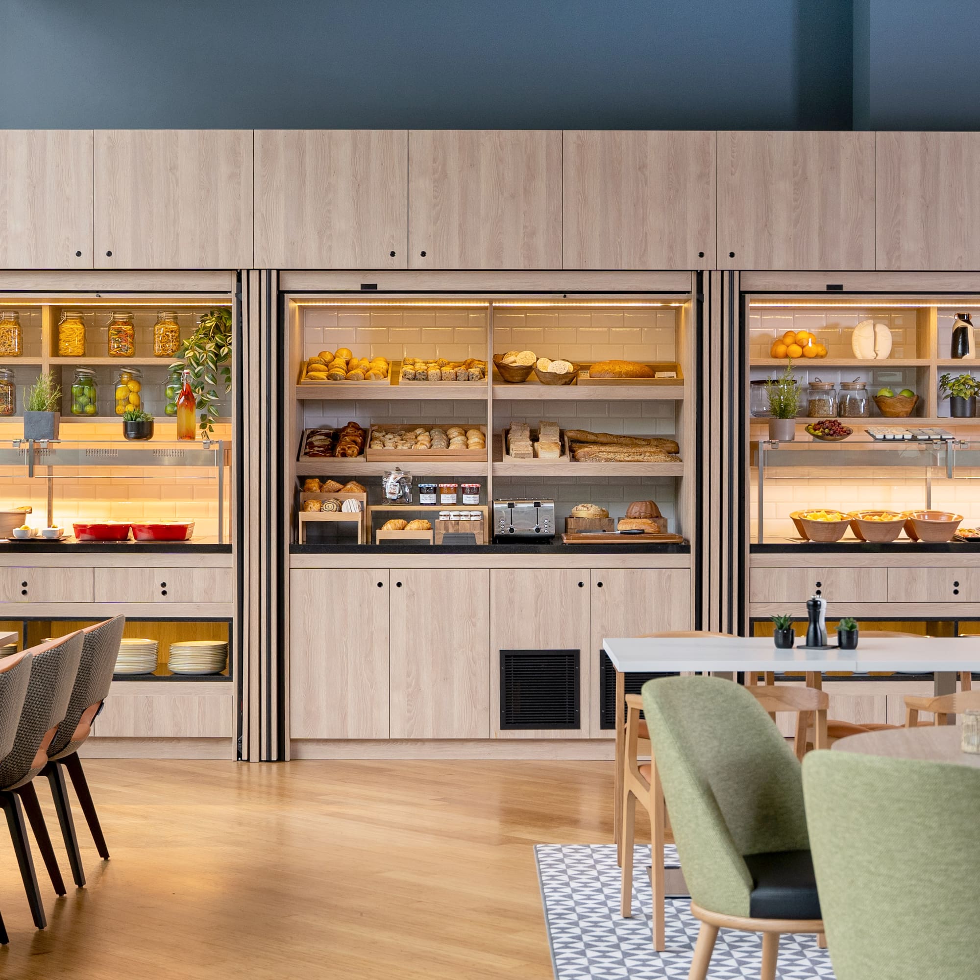 a room with a table and chairs and a display case