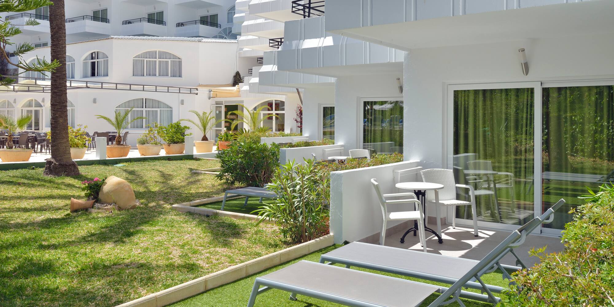 a white building with lawn chairs and a table