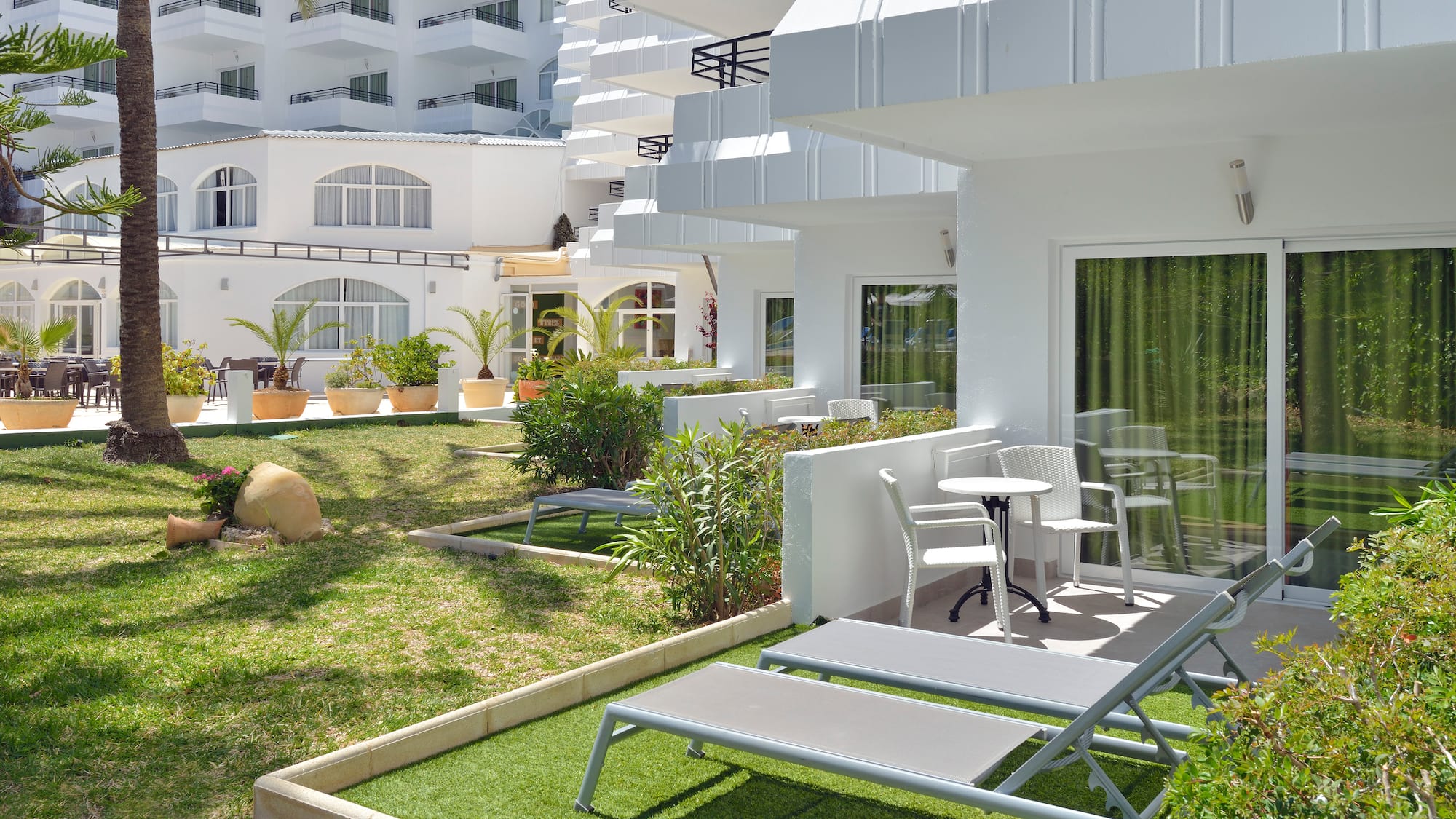 a white building with lawn chairs and a table