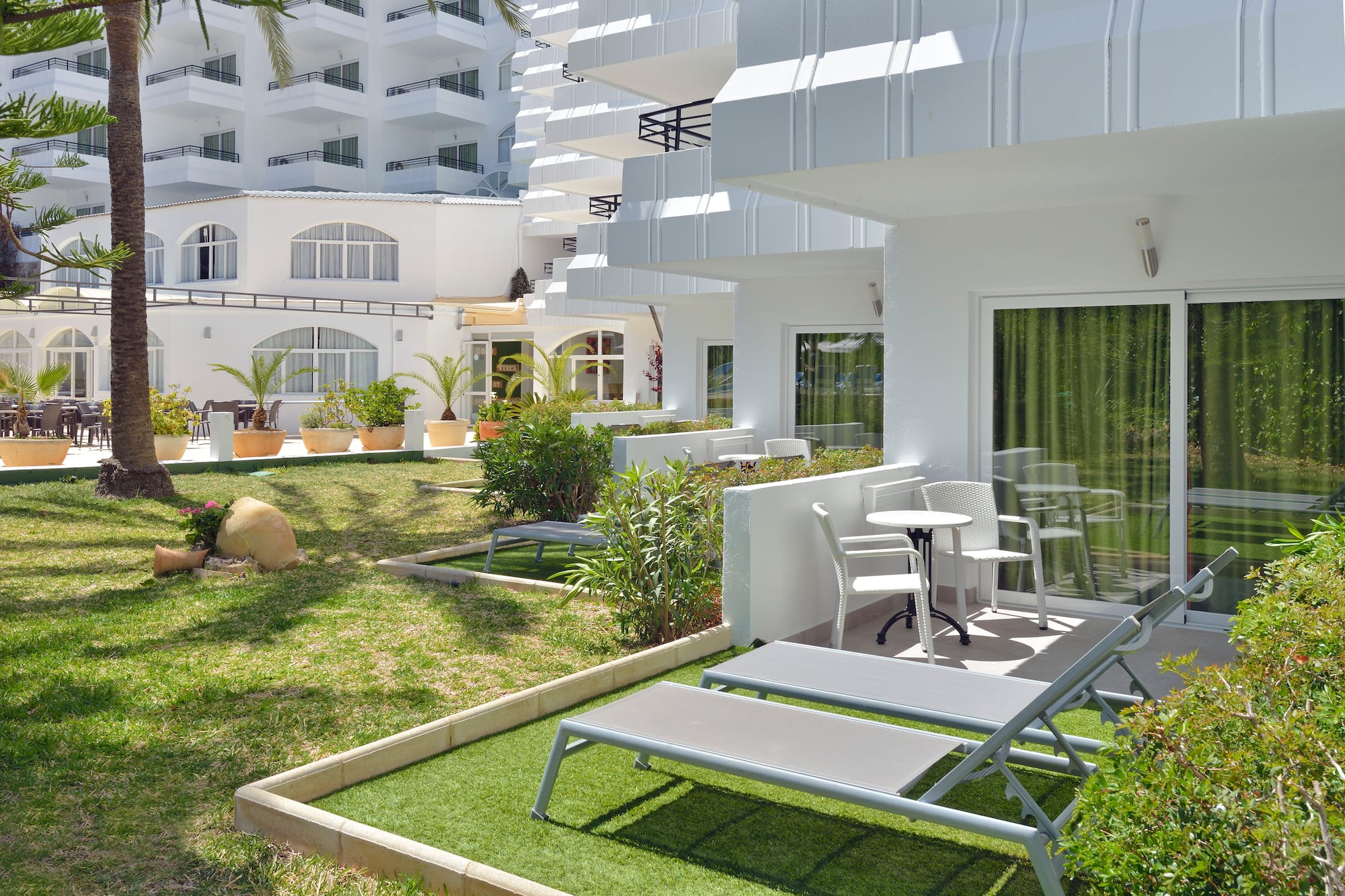 a white building with lawn chairs and a table