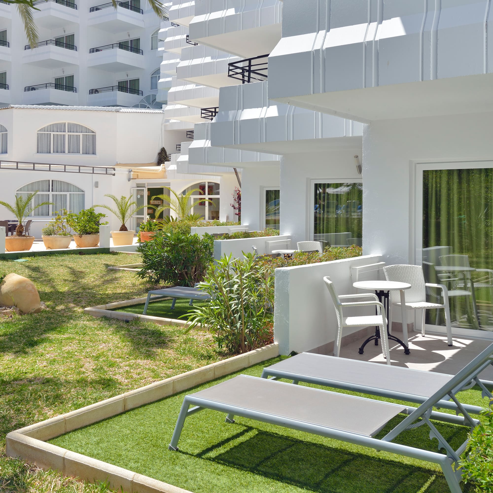 a white building with lawn chairs and a table