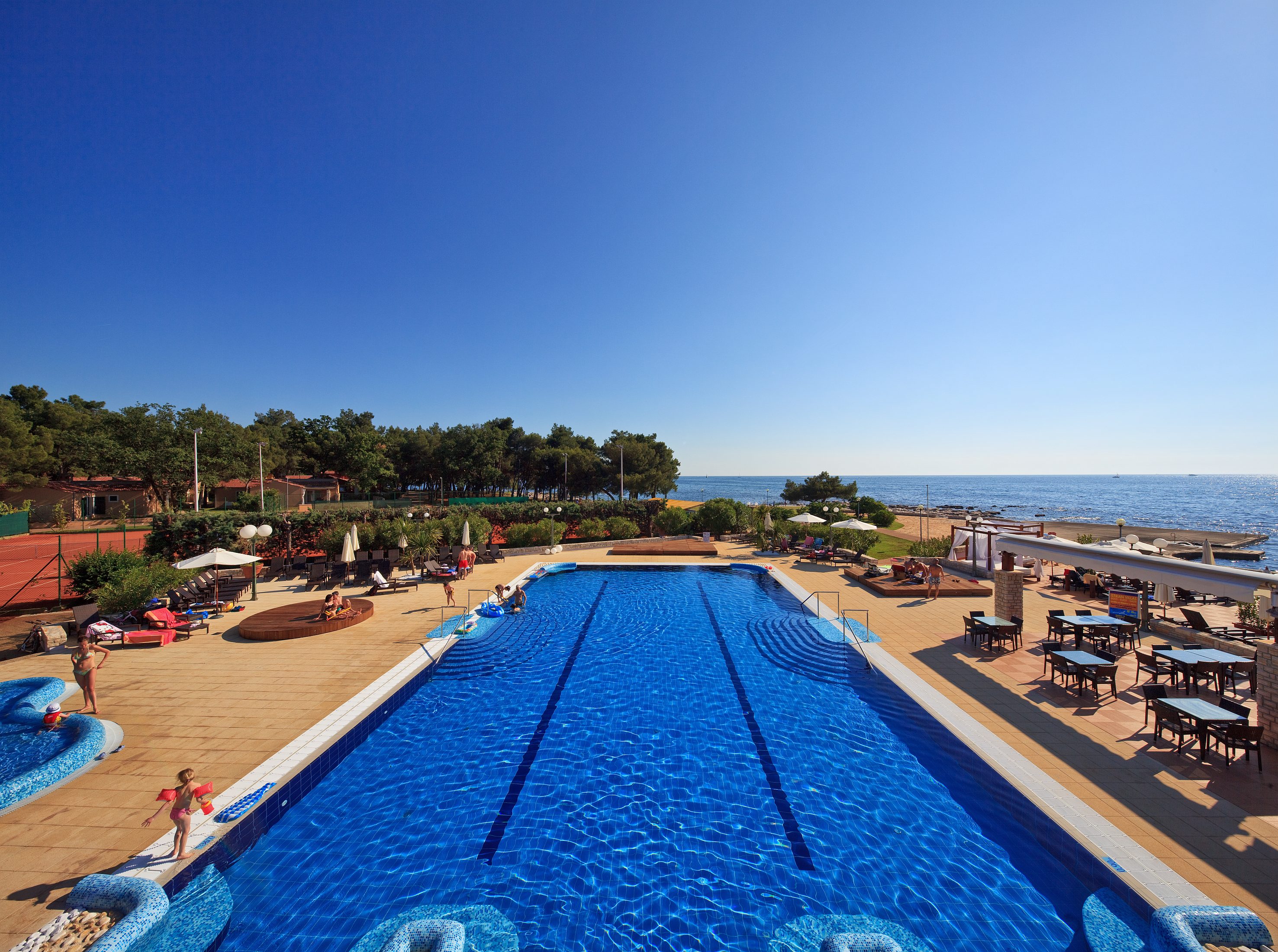 a swimming pool with people on the beach