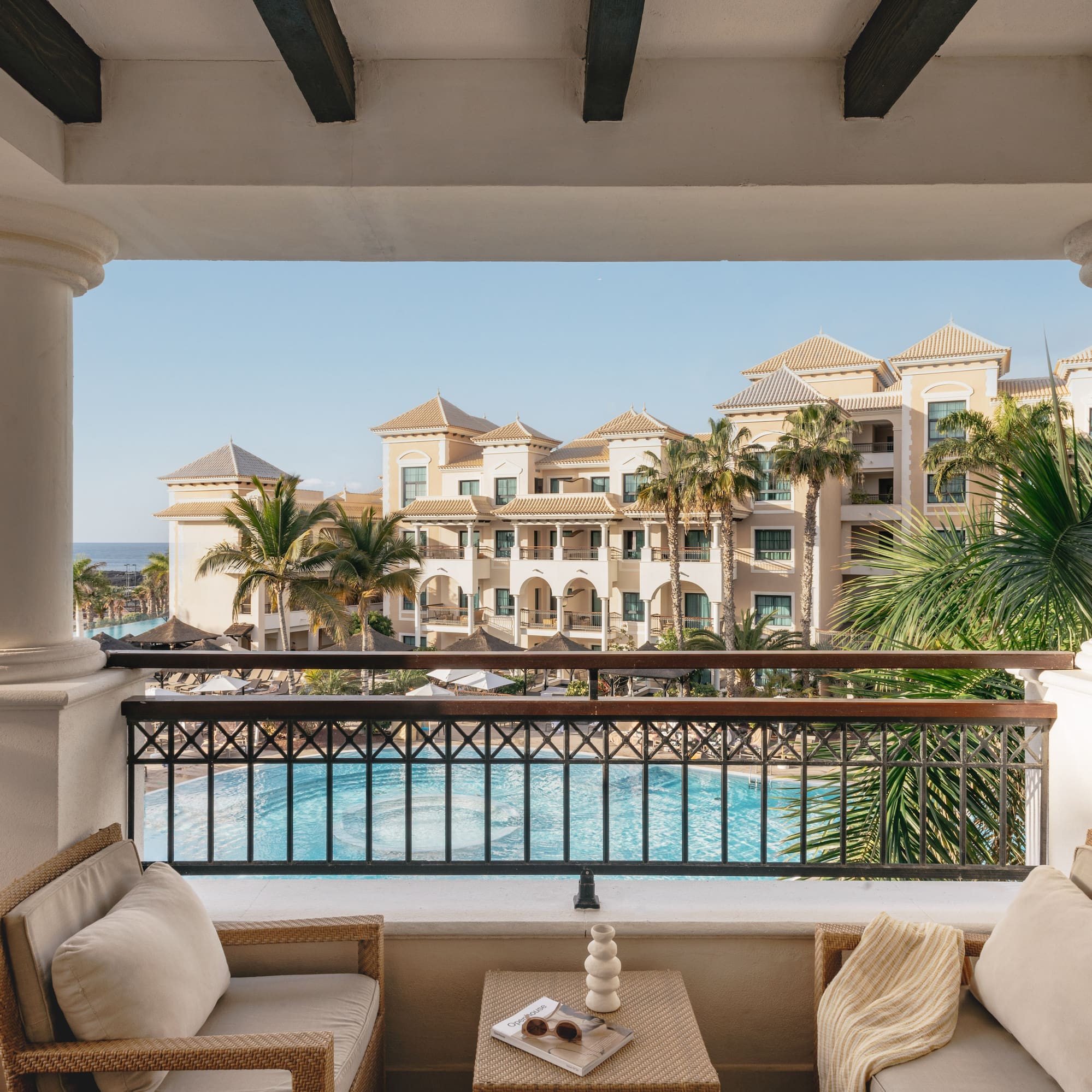 a balcony with a pool and chairs