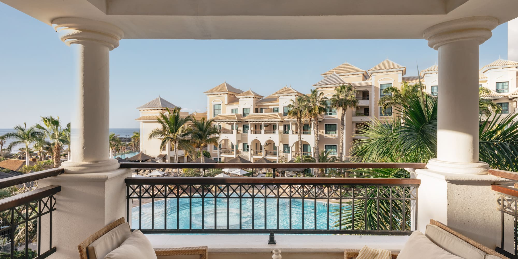a balcony with a pool and chairs