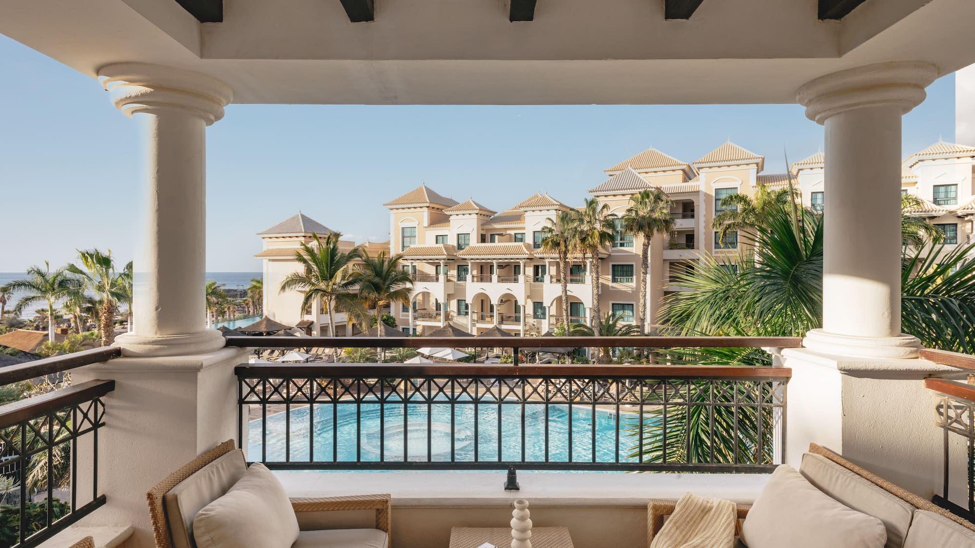 a balcony with a pool and chairs