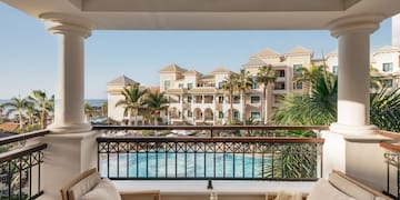 a balcony with a pool and chairs