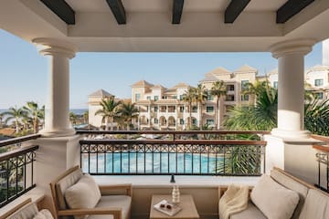 a balcony with a pool and chairs