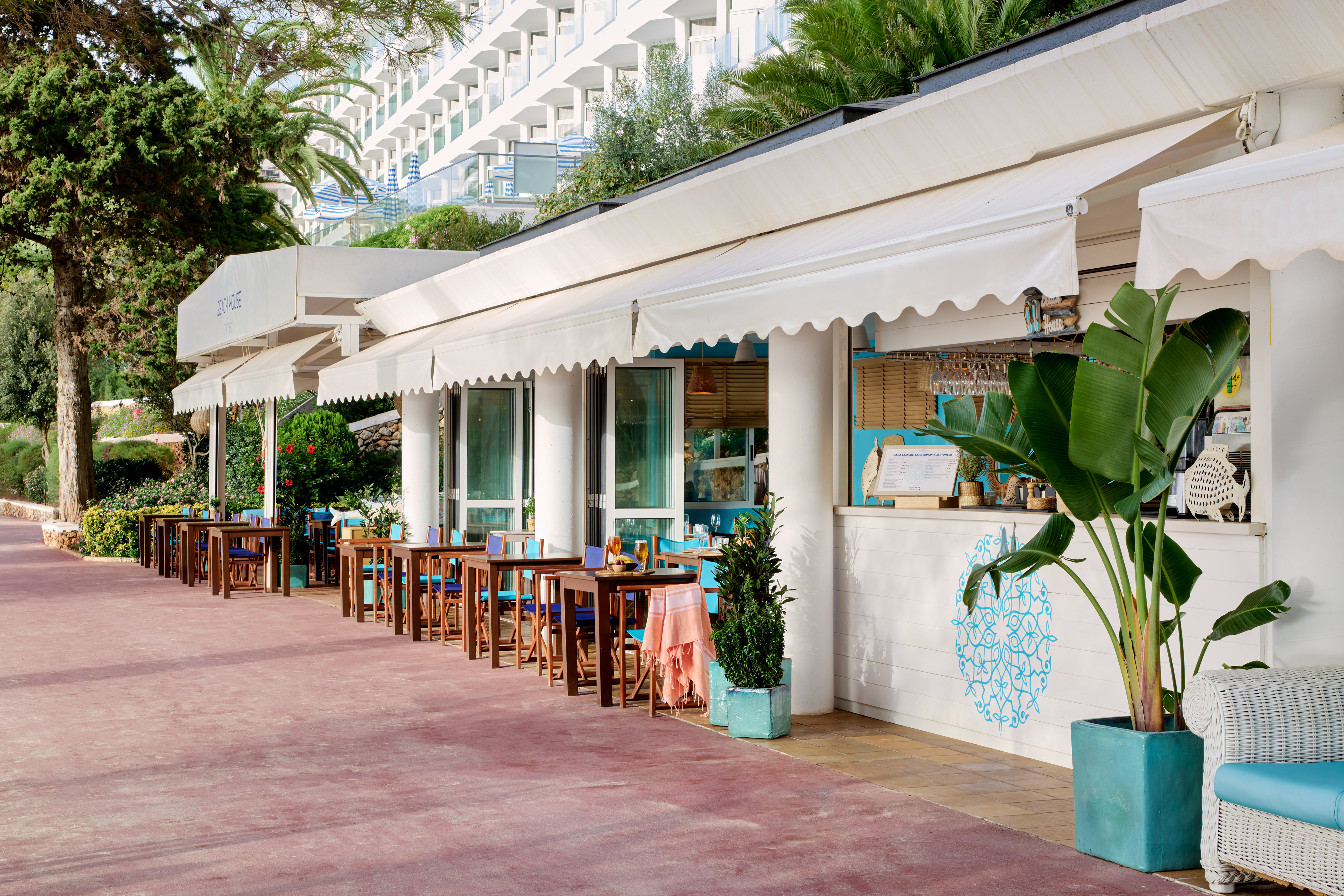 Outdoor Beach House restaurant terrace with white awnings at a resort.