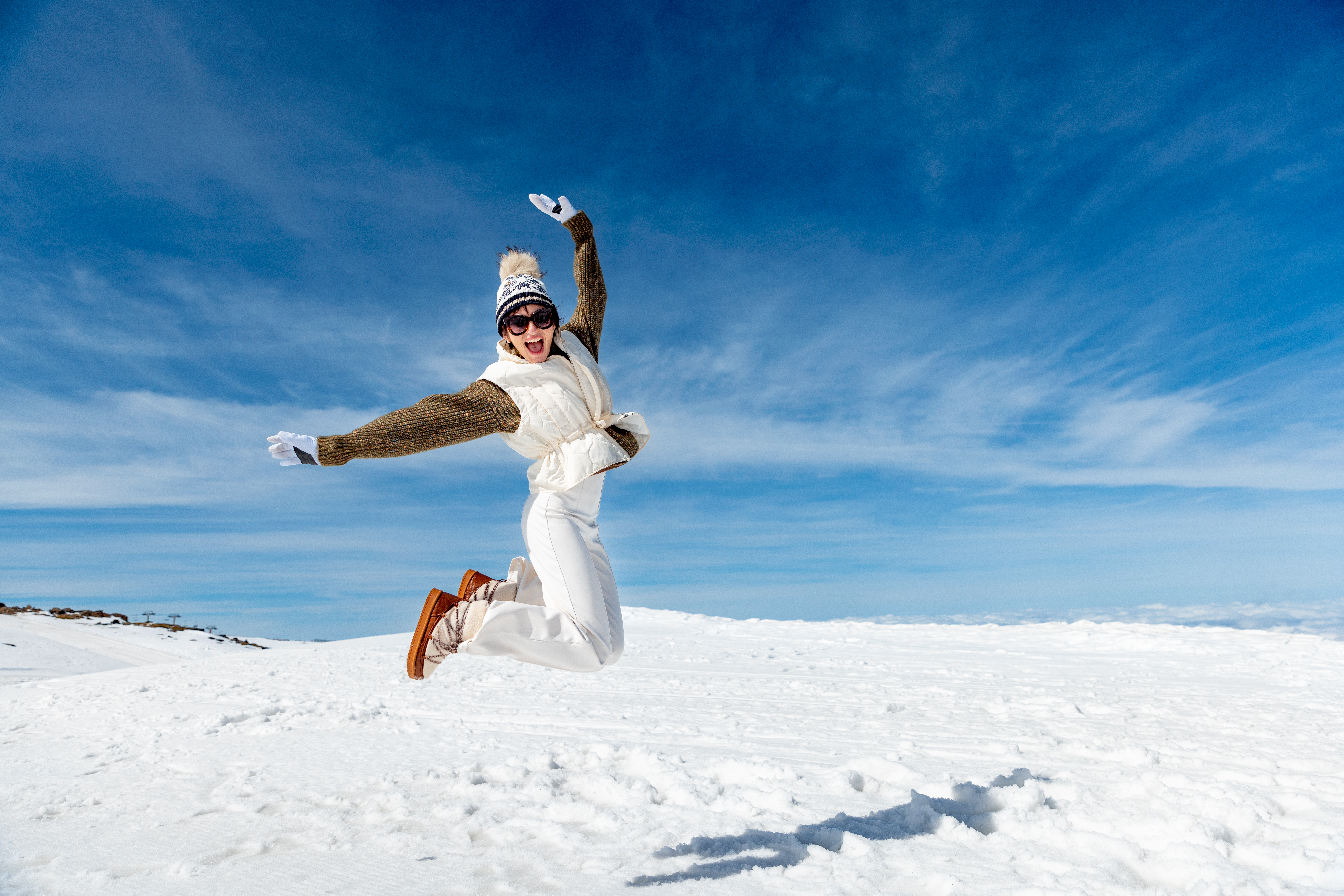 a woman jumping in the air in the snow