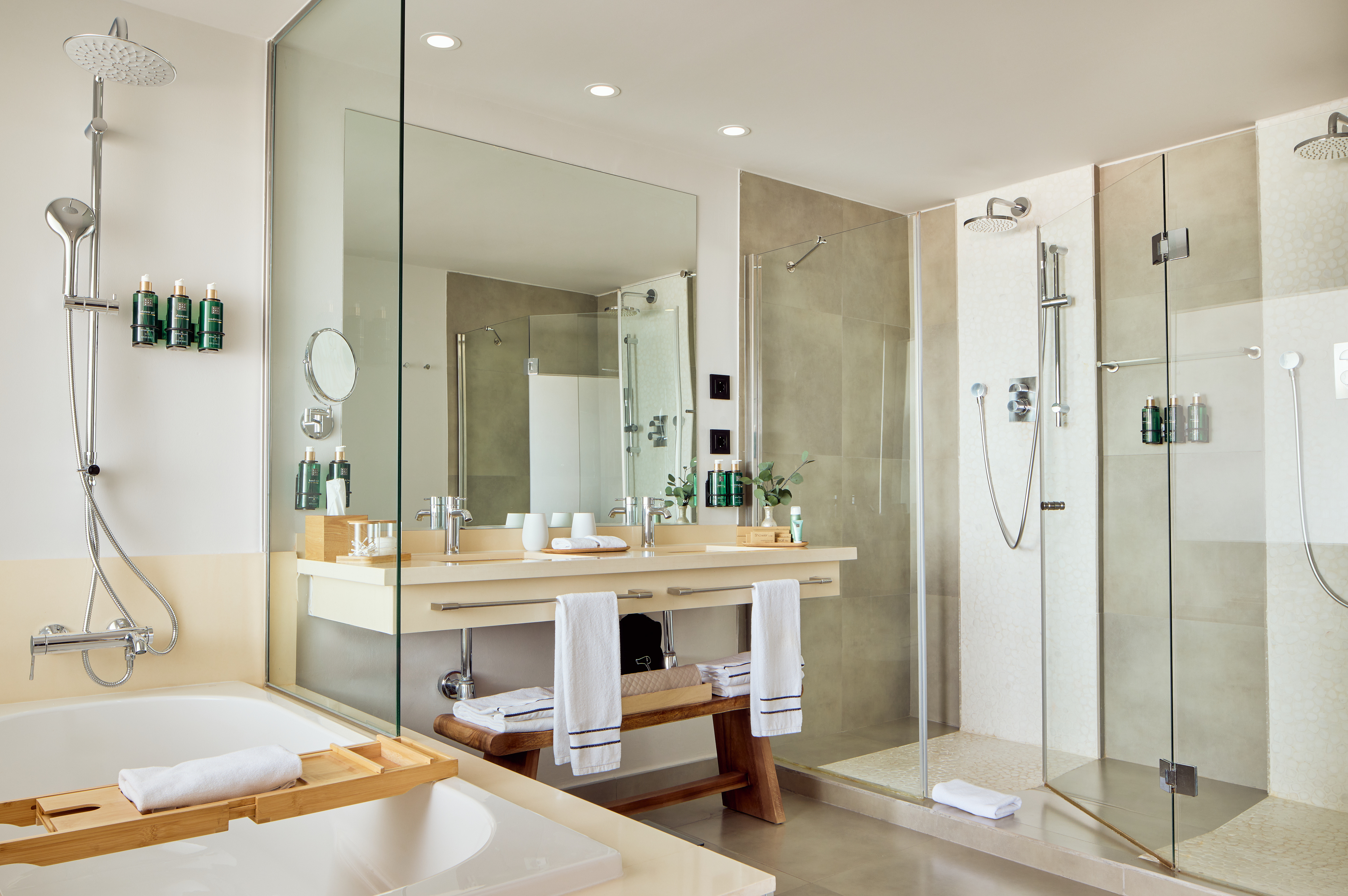 Luxury hotel bathroom featuring walk-in shower, bathtub, and double vanity.
