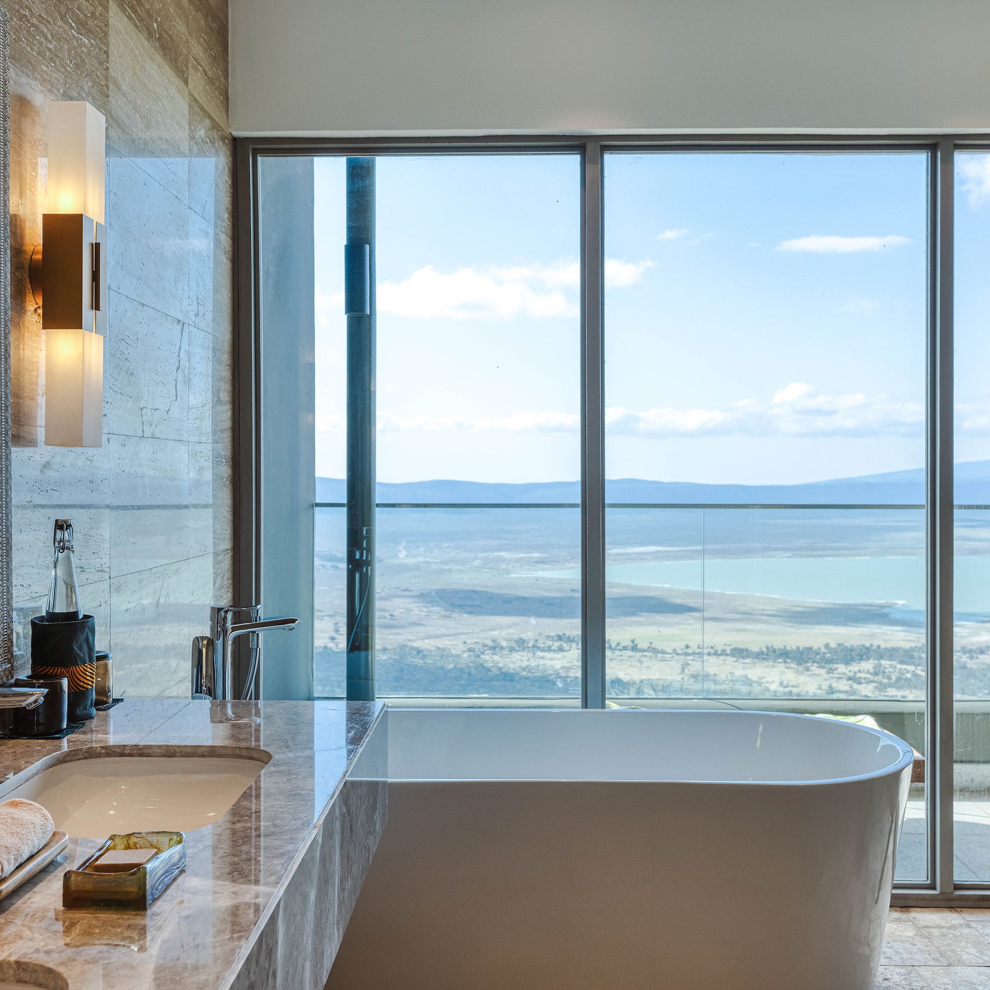 a bathroom with a large window overlooking a lake